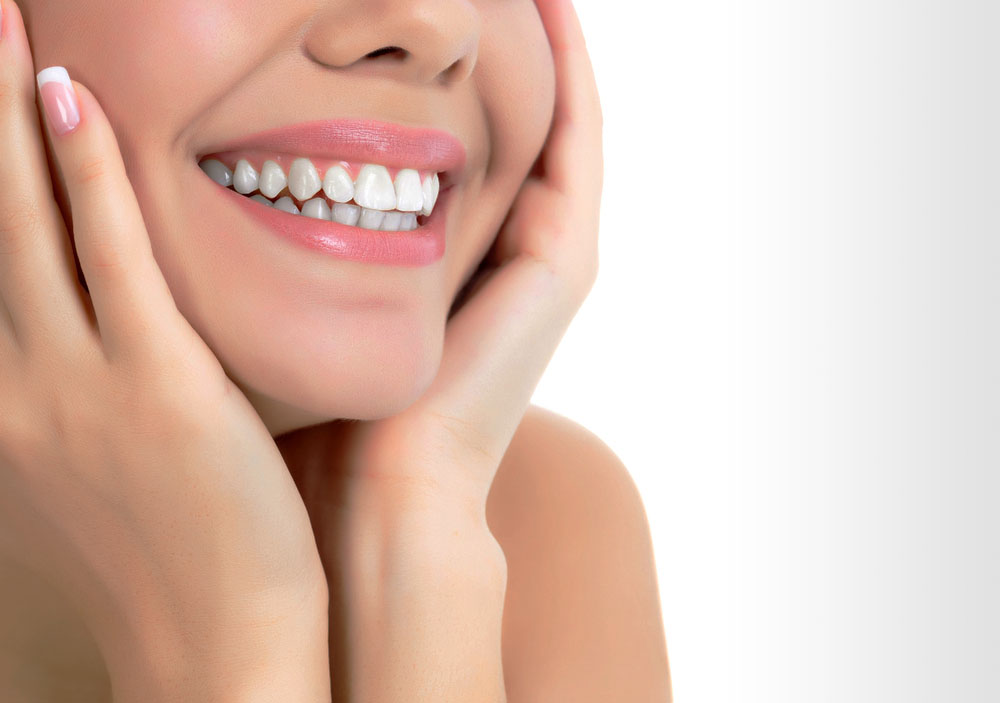 Perfect White Smile Close-Up – Dental Health & Beauty Concept - Dental Implants in Bakersfield Close-up of a bright, healthy smile with hands gently framing the face. Ideal for dental care, teeth whitening, and cosmetic dentistry promotion. - Dental Implants in Bakersfield