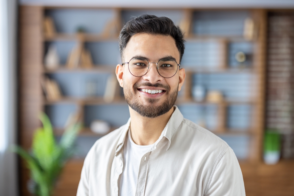 Smiling Young Man with Glasses – Casual Professional Portrait Friendly man wearing glasses smiling confidently in a modern interior. Great for business, personal branding, or lifestyle visuals.